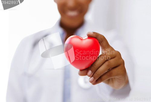 Image of african female doctor with red heart