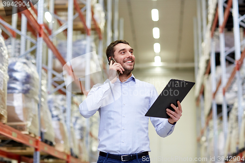 Image of man with clipboard and smartphone at warehouse