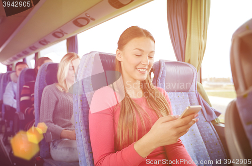 Image of happy woman sitting in travel bus with smartphone