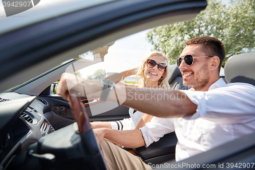 Image of happy man and woman driving in cabriolet car