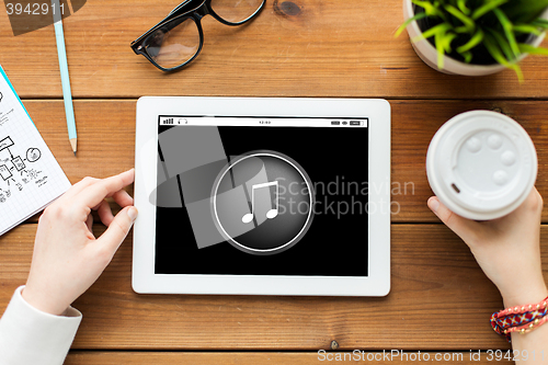 Image of close up of woman with tablet pc on wooden table