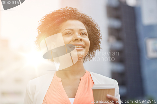 Image of happy african businesswoman with coffee in city