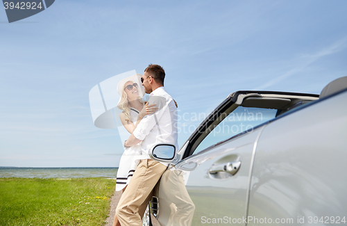 Image of happy couple hugging near cabriolet car at sea