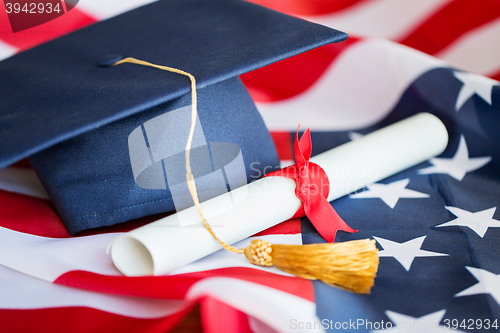 Image of bachelor hat and diploma on american flag