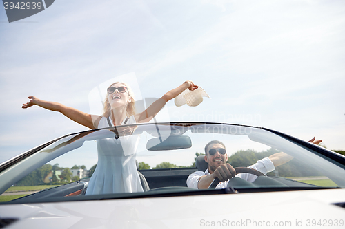 Image of happy man and woman driving in cabriolet car