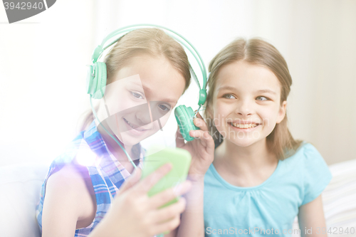 Image of happy girls with smartphone and headphones