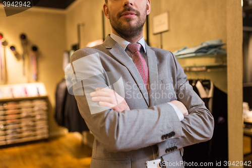 Image of close up of man in suit and tie at clothing store