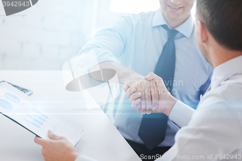 Image of businessmen shaking hands in office