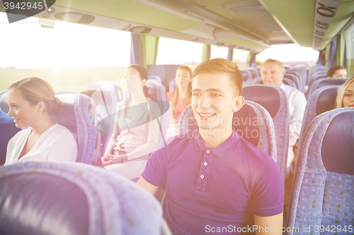 Image of happy young man sitting in travel bus or train