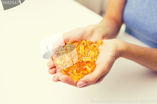 Image of close up of woman hands holding pills or capsules