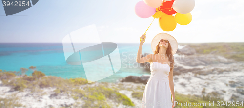 Image of smiling young woman in sunglasses with balloons