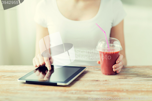 Image of close up of woman with tablet pc and smoothie