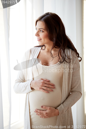 Image of happy pregnant woman with big tummy at home