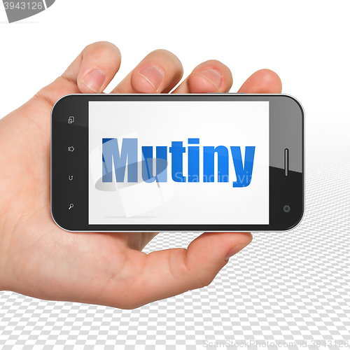 Image of Political concept: Hand Holding Smartphone with Mutiny on display