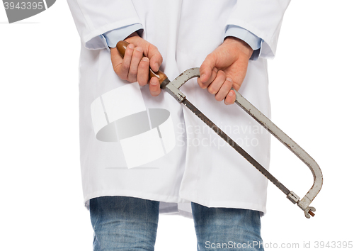 Image of Crazy doctor is holding a big saw in his hands