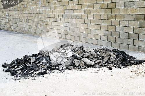 Image of Old asphalt pieces stacked in a pile on the sidewalk
