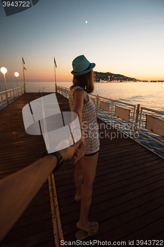 Image of Girl holding a hand man on the beach