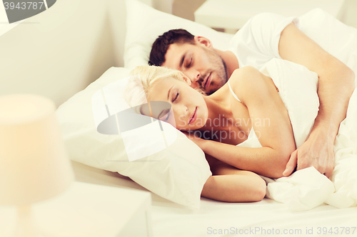 Image of happy couple sleeping in bed at home