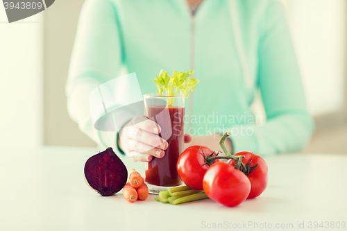 Image of close up of woman hands with juice and vegetables