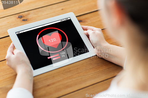 Image of close up of woman with tablet pc on wooden table