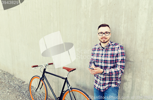 Image of hipster man in earphones with smartphone and bike