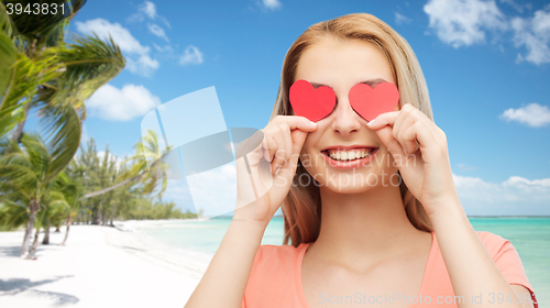 Image of happy young woman with red heart shapes on eyes