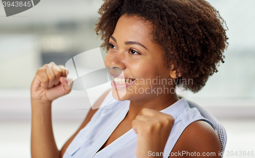 Image of happy african young woman with raised fists