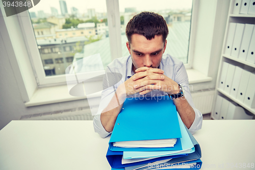 Image of businessman taking papers from secretary in office