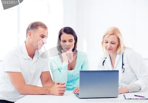 Image of doctor with patients looking at laptop