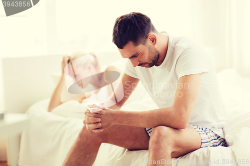 Image of unhappy couple having problems at bedroom