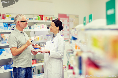 Image of pharmacist and senior man buying drug at pharmacy