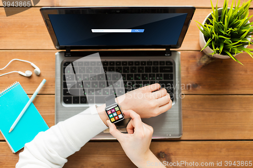 Image of close up of woman with smart watch and laptop