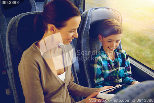Image of happy family with tablet pc sitting in travel bus