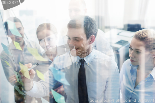 Image of smiling business people with marker and stickers