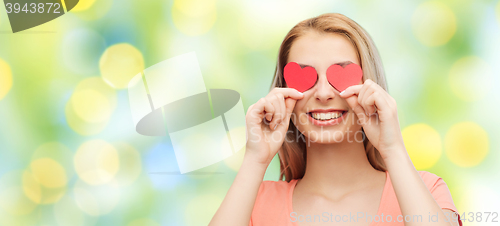 Image of happy young woman with red heart shapes on eyes