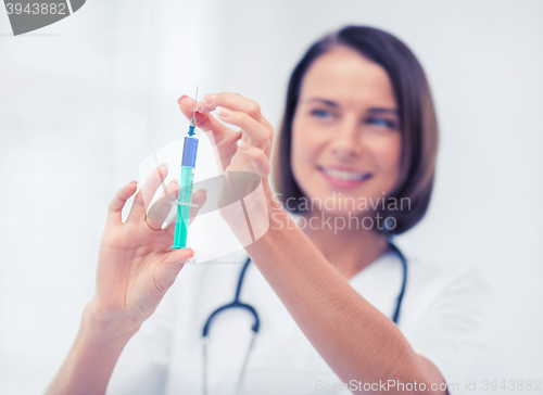 Image of female doctor holding syringe with injection