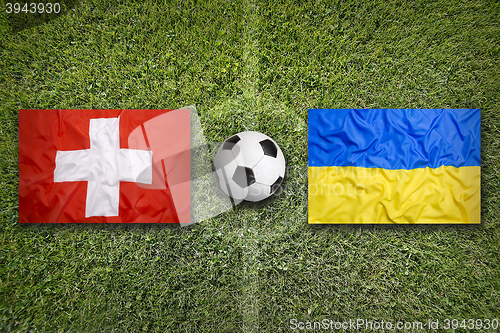 Image of Switzerland vs. Ukraine flags on soccer field
