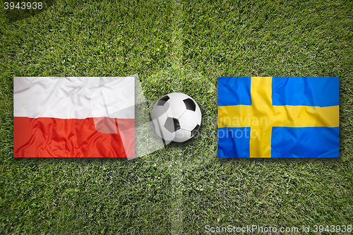 Image of Poland vs. Sweden flags on soccer field