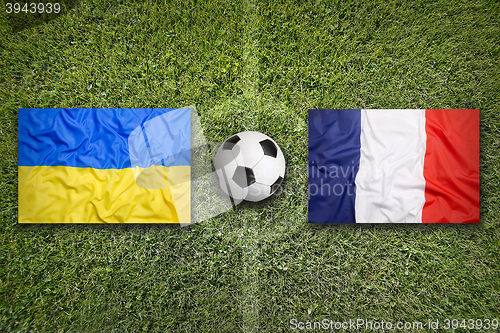 Image of Ukraine vs. France flags on soccer field