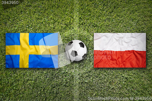 Image of Sweden vs. Poland flags on soccer field