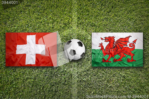 Image of Switzerland vs. Wales flags on soccer field