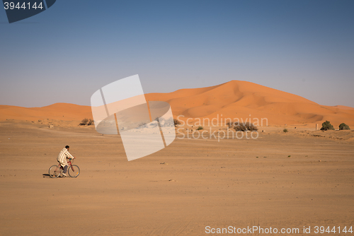 Image of Man riding on a bike in Hassilabied, desert village in Morocco.