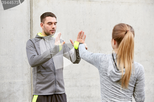 Image of woman with trainer working out self defense strike