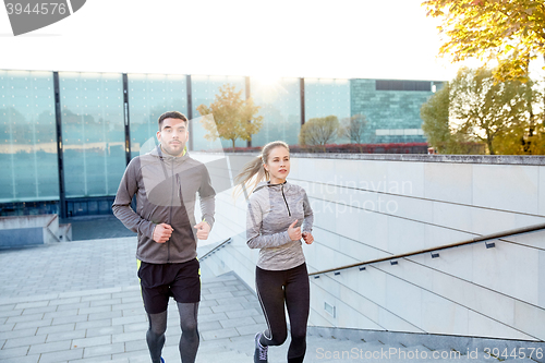 Image of happy couple running upstairs on city stairs