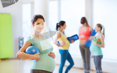 Image of happy pregnant woman with ball in gym