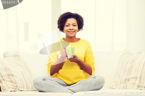 Image of happy african american woman drinking from tea cup