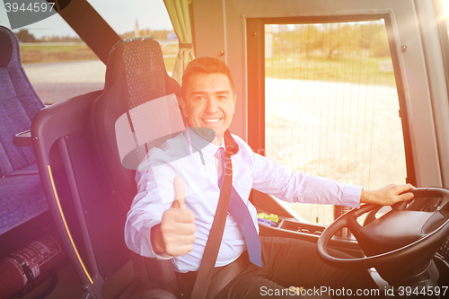 Image of happy driver driving bus and snowing thumbs up