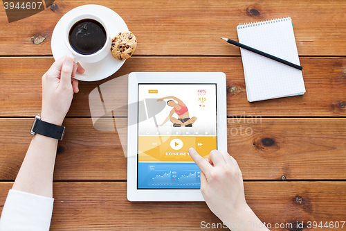 Image of close up of woman with tablet pc on wooden table