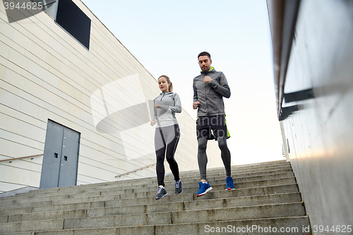 Image of happy couple running downstairs in city