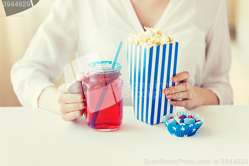 Image of woman with popcorn and drink in glass mason jar